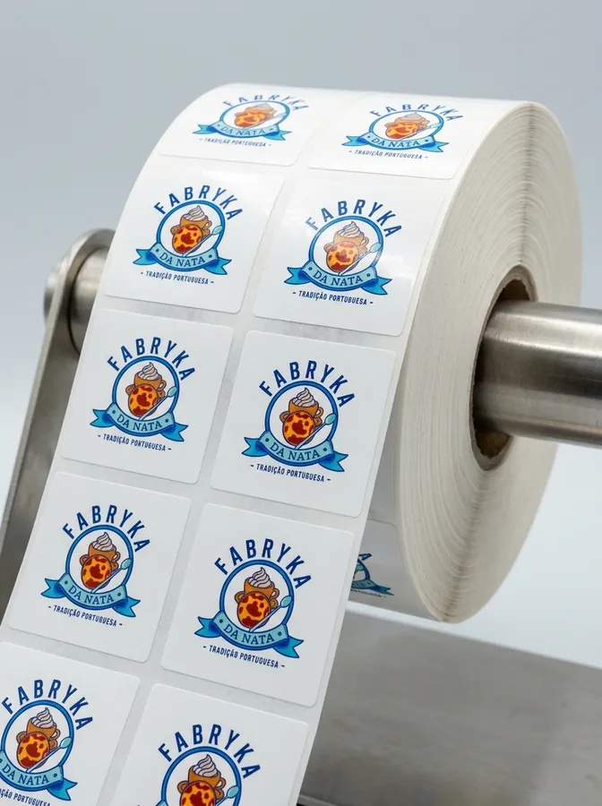 Rola naklejek z logo Fabryka da Nata na maszynie produkcyjnej